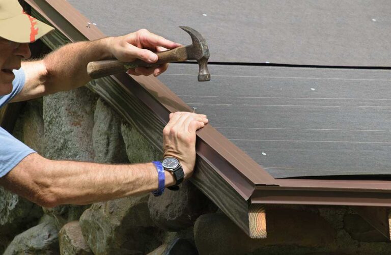 A residential skylight surrounded by roof shingles with light snow and visible interior trim.